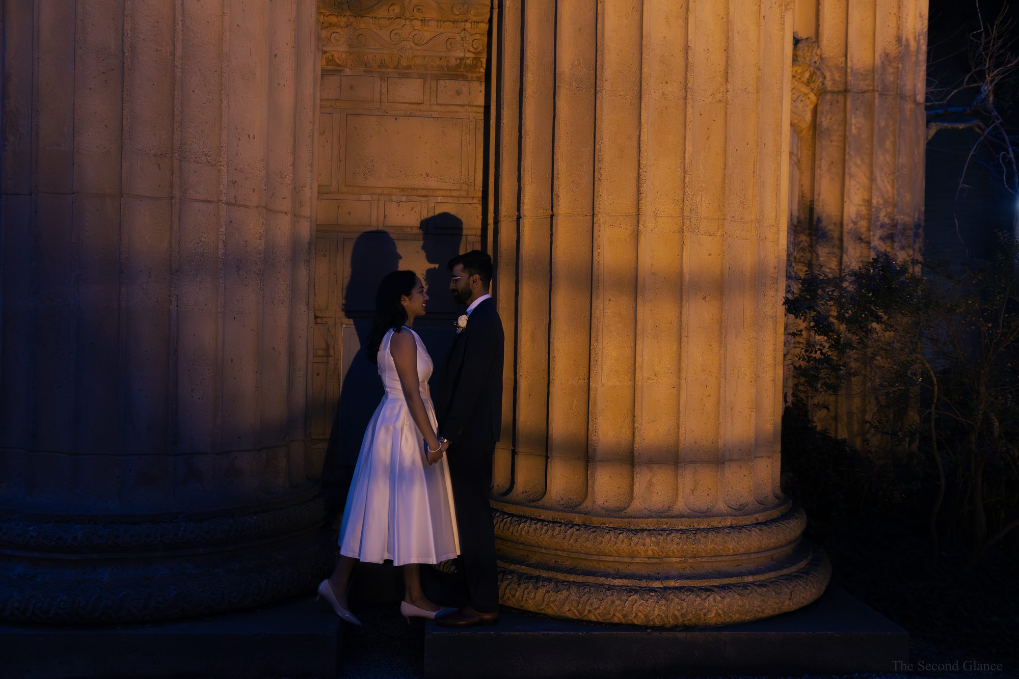 Couple between glowing columns at night