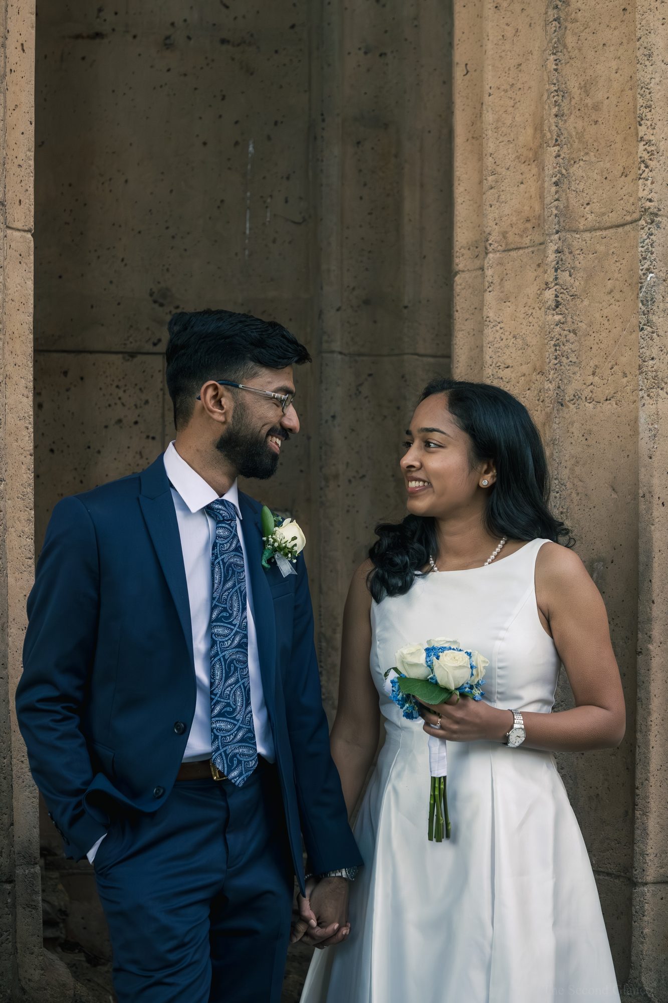 Couple against stone column