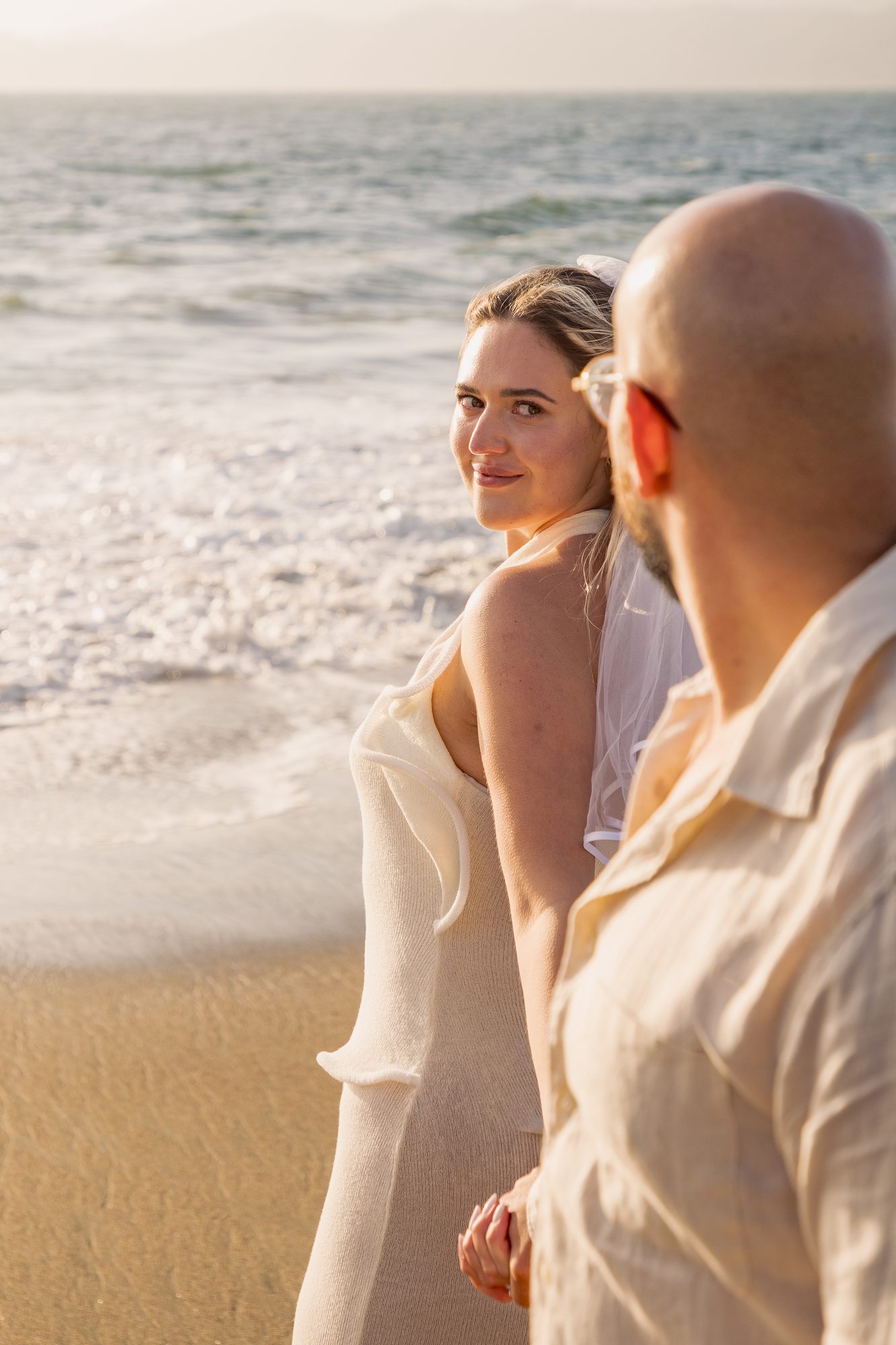 She glances back, golden light at the shore