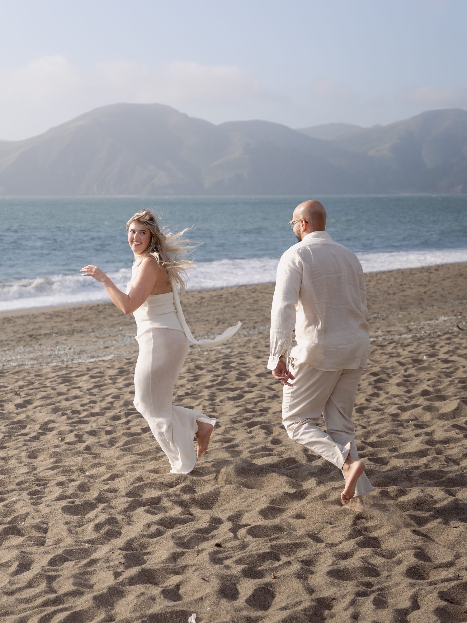 Couple running barefoot along the shore